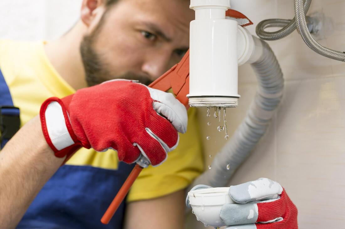 plumber fixing the sink pipe