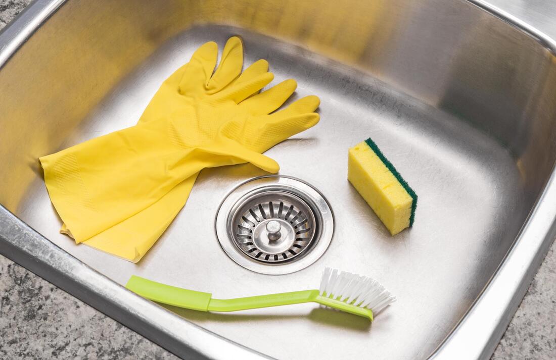 a rubber gloves, sponge and brush on the sink