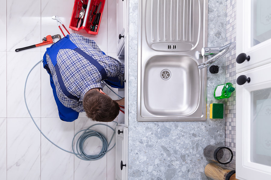 plumber fixing the kitchen sink 